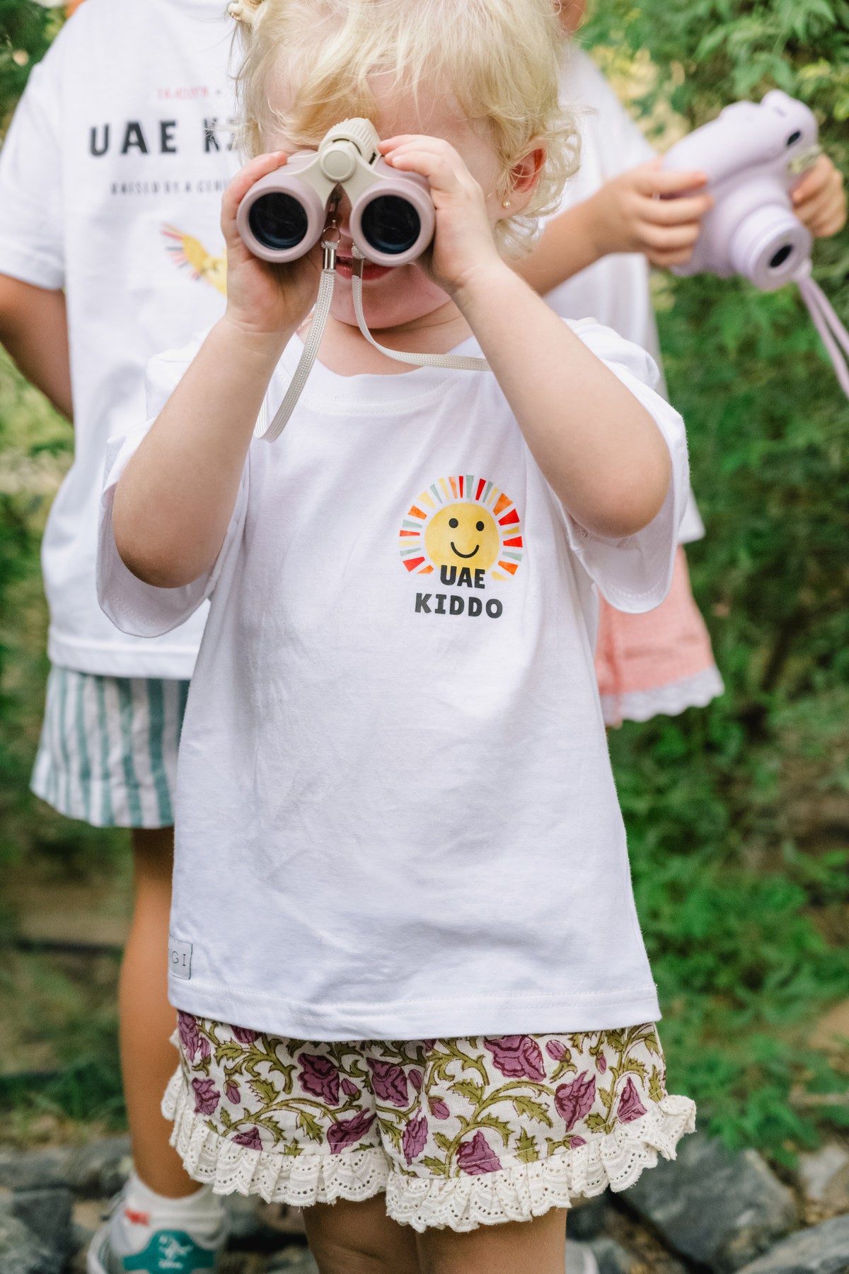 Child with binoculars wearing UAE Kiddo
